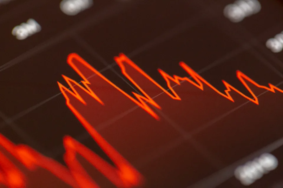 Market data on trading screens in a darkened room
