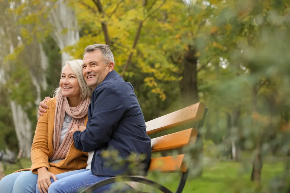 An older couple walking together through a park